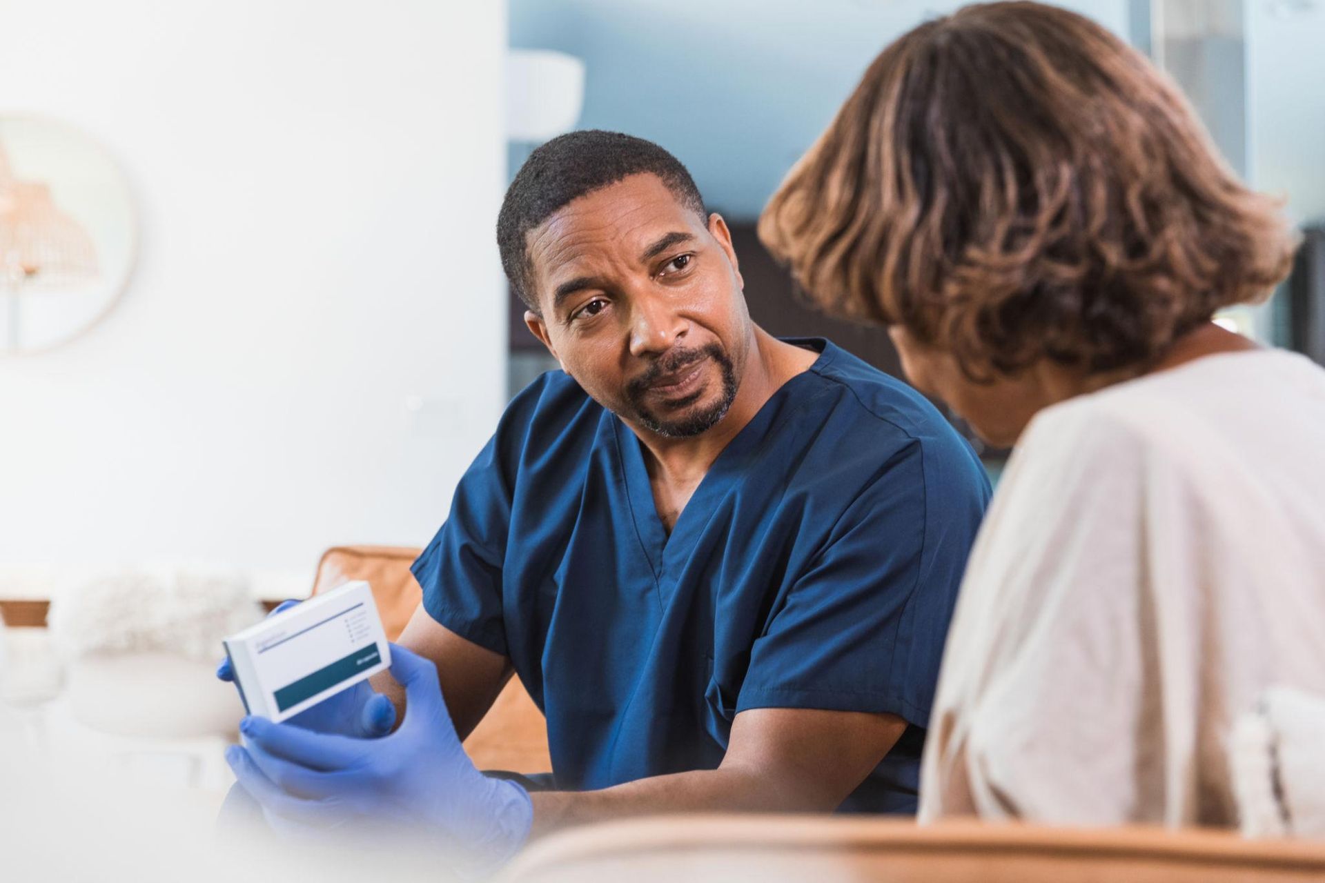 Community health professional listening to a patient during a home visit